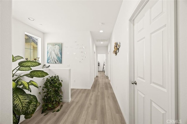 hallway with light wood-type flooring, baseboards, and recessed lighting