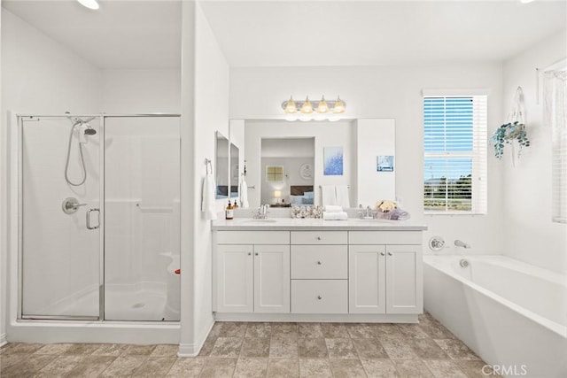 bathroom with a shower stall, double vanity, and a garden tub