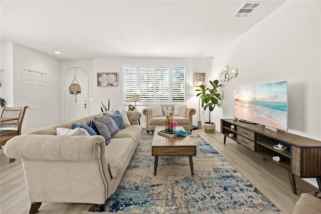 living room with light wood-type flooring and recessed lighting