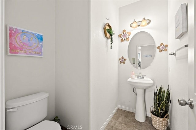bathroom featuring toilet and baseboards