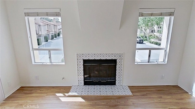137 Corsica Dr, Newport Beach, CA 92660 - unfurnished living room featuring wood finished floors, a tiled fireplace, and baseboards