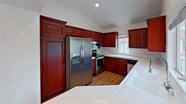 137 Corsica Dr, Newport Beach, CA 92660 - kitchen with stainless steel appliances, dark brown cabinets, vaulted ceiling, plenty of natural light, and light countertops