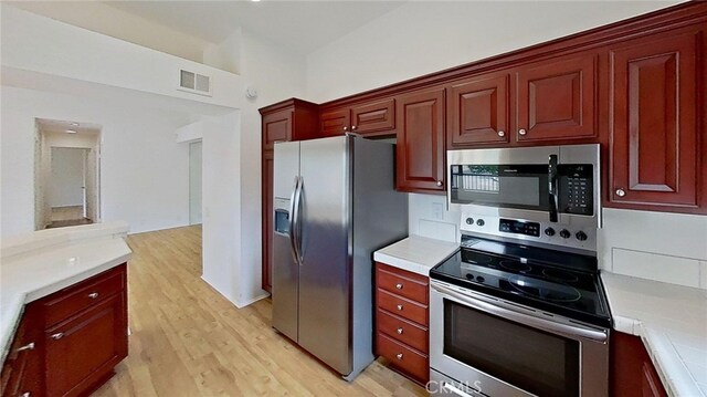 137 Corsica Dr, Newport Beach, CA 92660 - kitchen with appliances with stainless steel finishes, light countertops, light wood-type flooring, and dark brown cabinets
