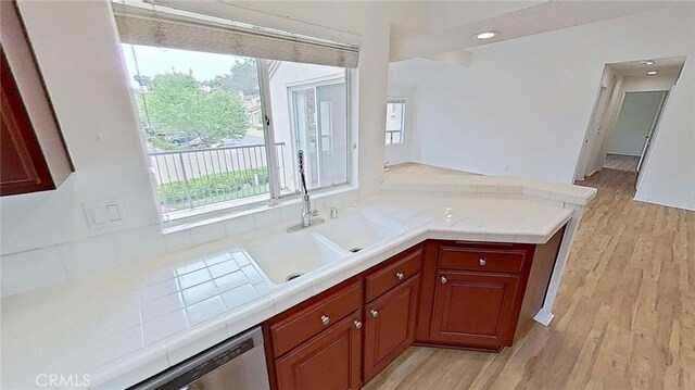 137 Corsica Dr, Newport Beach, CA 92660 - kitchen featuring a sink, tile countertops, light wood finished floors, stainless steel dishwasher, and a peninsula