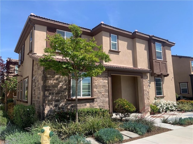 7135 Montecito Ln, Eastvale, CA 92880 - view of front of home featuring stone siding, a tile roof, and stucco siding