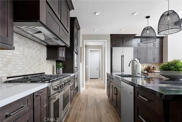 16402 Ginger Creek Dr, Riverside, CA 92504 - kitchen with high end appliances, dark brown cabinets, light wood-style flooring, backsplash, and recessed lighting