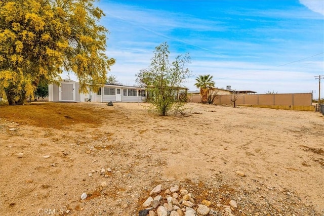 5799 Halsey Ave Unit 29, Palms, CA 92277 - view of yard with a storage unit, fence, an outbuilding, and a sunroom