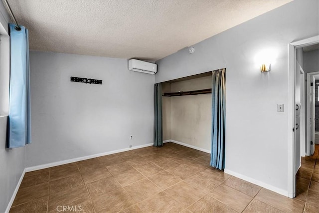 5799 Halsey Ave Unit 29, Palms, CA 92277 - unfurnished bedroom with a textured ceiling, a wall mounted AC, a closet, tile patterned floors, and baseboards