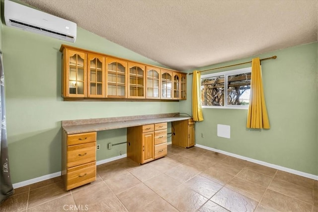 5799 Halsey Ave Unit 29, Palms, CA 92277 - unfurnished office featuring a wall unit AC, a textured ceiling, built in desk, lofted ceiling, and light tile patterned floors