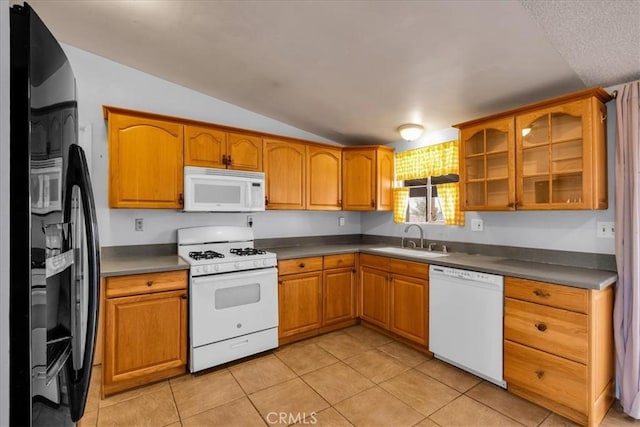 5799 Halsey Ave Unit 29, Palms, CA 92277 - kitchen featuring white appliances, a sink, vaulted ceiling, light tile patterned flooring, and brown cabinets