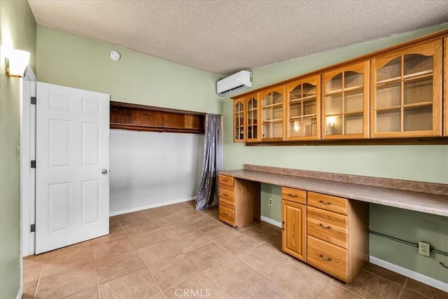 5799 Halsey Ave Unit 29, Palms, CA 92277 - unfurnished office featuring built in study area, a wall mounted AC, a textured ceiling, baseboards, and light tile patterned floors