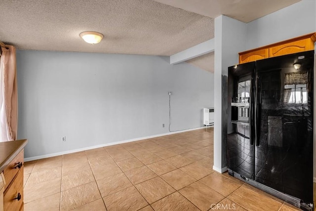 5799 Halsey Ave Unit 29, Palms, CA 92277 - kitchen featuring black fridge, light tile patterned floors, baseboards, and a textured ceiling