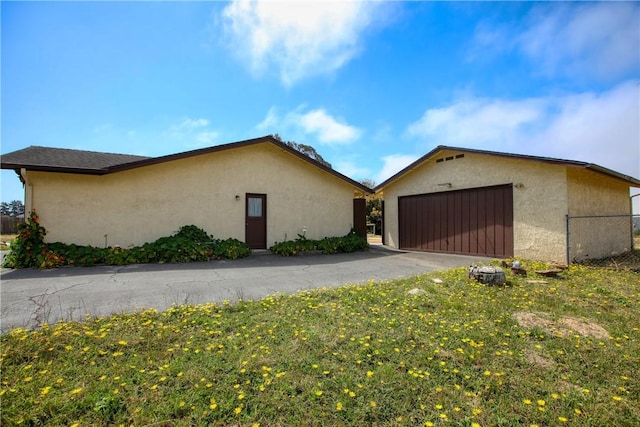 2661 Southview Ave, Arroyo Grande, CA 93420 - view of side of home with stucco siding, fence, a garage, and asphalt driveway