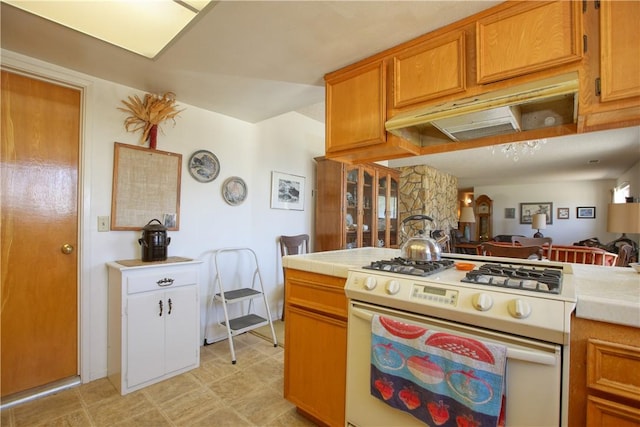2661 Southview Ave, Arroyo Grande, CA 93420 - kitchen featuring white gas stove, tile countertops, brown cabinetry, and under cabinet range hood