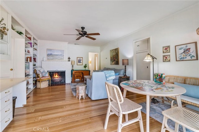 1981 Sinaloa Ave, Altadena, CA 91001 - dining area with a ceiling fan, light wood-style flooring, a fireplace, and crown molding