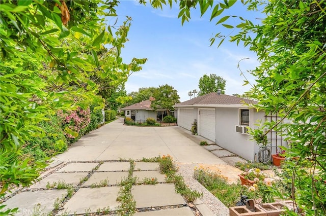 1981 Sinaloa Ave, Altadena, CA 91001 - back of property with stucco siding, a garage, cooling unit, and concrete driveway