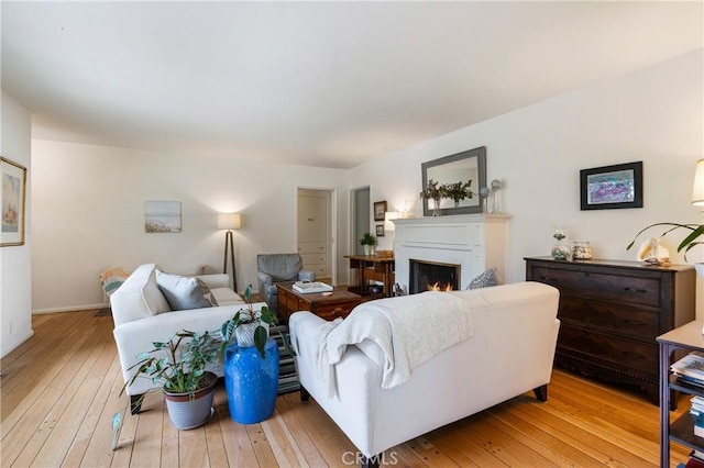 1981 Sinaloa Ave, Altadena, CA 91001 - living room with light wood-style floors, a warm lit fireplace, and baseboards