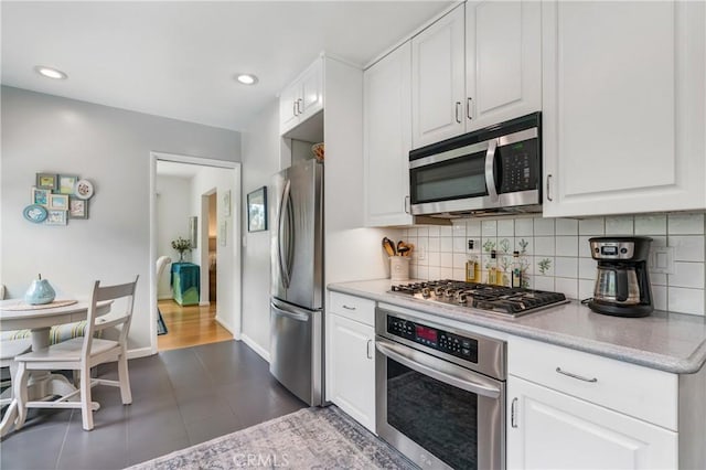 1981 Sinaloa Ave, Altadena, CA 91001 - kitchen featuring stainless steel appliances, decorative backsplash, white cabinetry, dark tile patterned floors, and recessed lighting