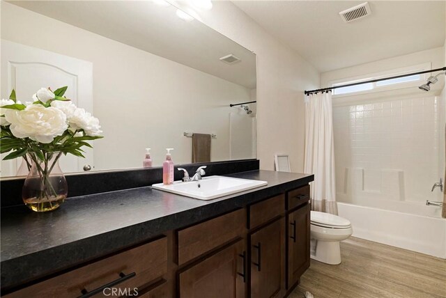 1612 San Jose Ln, Paradise, CA 95969 - bathroom featuring wood finished floors, toilet, vanity, and shower / bathtub combination with curtain