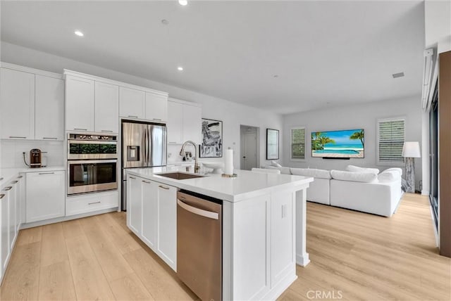 107 Plum Lily, Irvine, CA 92618 - kitchen featuring stainless steel appliances, a sink, light wood finished floors, open floor plan, and light countertops