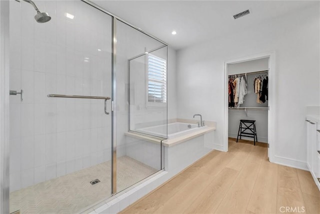 107 Plum Lily, Irvine, CA 92618 - full bath featuring wood finished floors, a shower stall, a garden tub, a walk in closet, and vanity