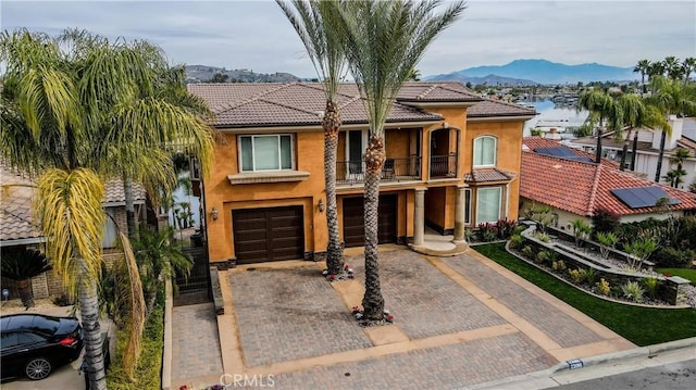 23180 Gray Fox Dr, Canyon Lake, CA 92587 - view of front of home with a balcony, a garage, driveway, stucco siding, and a tile roof