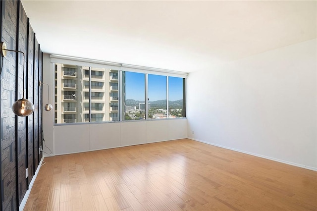 empty room featuring wood finished floors and baseboards