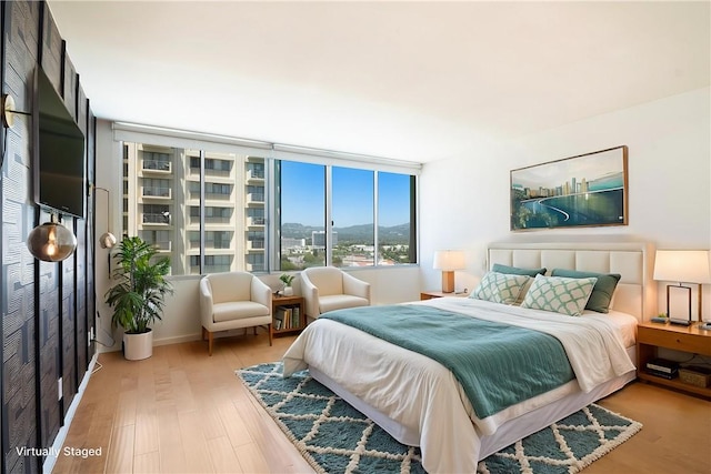 bedroom featuring light wood-type flooring and a mountain view