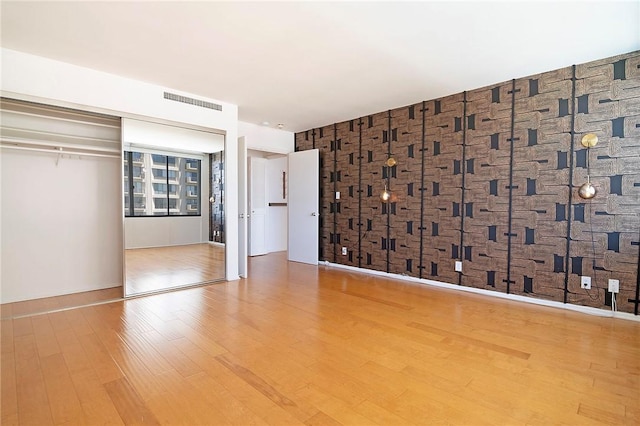 unfurnished bedroom with wood finished floors and a closet