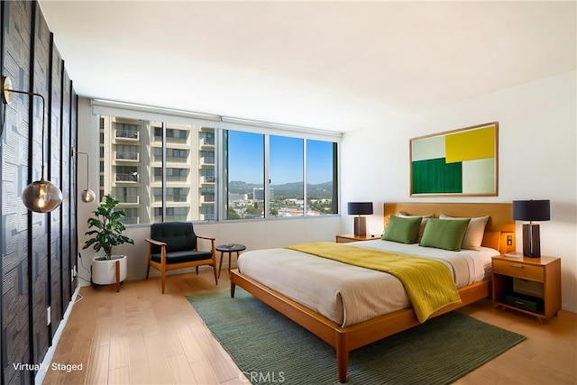 bedroom featuring wood finished floors and a mountain view