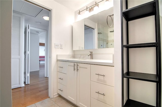 bathroom featuring vanity, a shower, tile patterned floors, and baseboards