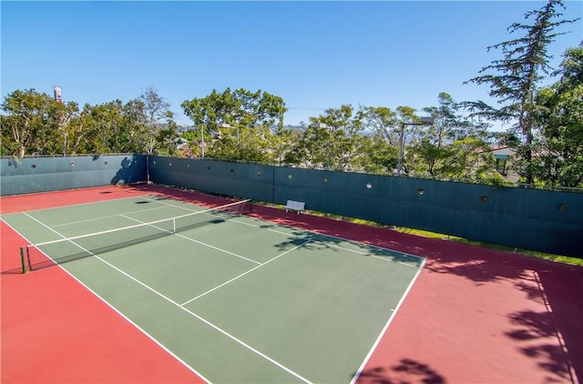 view of tennis court with fence and community basketball court