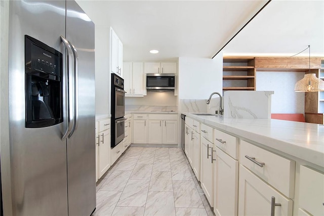 kitchen with appliances with stainless steel finishes, a sink, light marble finish flooring, light stone counters, and white cabinets