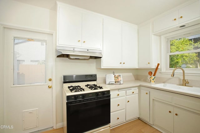 3749 Fairesta St, La Crescenta, CA 91214 - kitchen featuring range with gas stovetop, under cabinet range hood, a sink, white cabinets, and light countertops