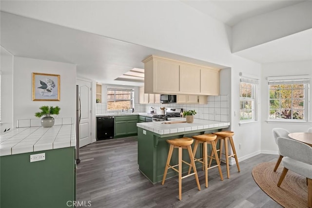 289 Irish Way, Pismo Beach, CA 93449 - kitchen with black appliances, tile countertops, a peninsula, green cabinets, and backsplash