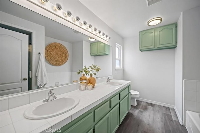 289 Irish Way, Pismo Beach, CA 93449 - bathroom with toilet, wood finished floors, a bath, baseboards, and double vanity