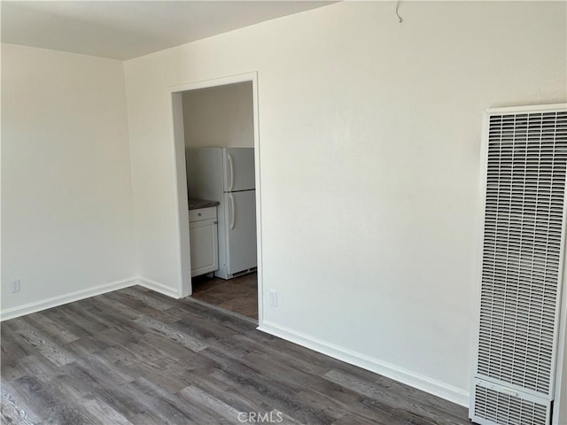 6688 Yucca Ave Unit 29, Palms, CA 92277 - empty room with a heating unit, dark wood-style floors, and baseboards