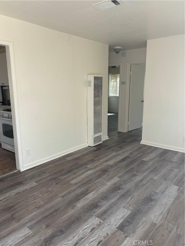 6688 Yucca Ave Unit 29, Palms, CA 92277 - unfurnished room with a heating unit, dark wood finished floors, and baseboards