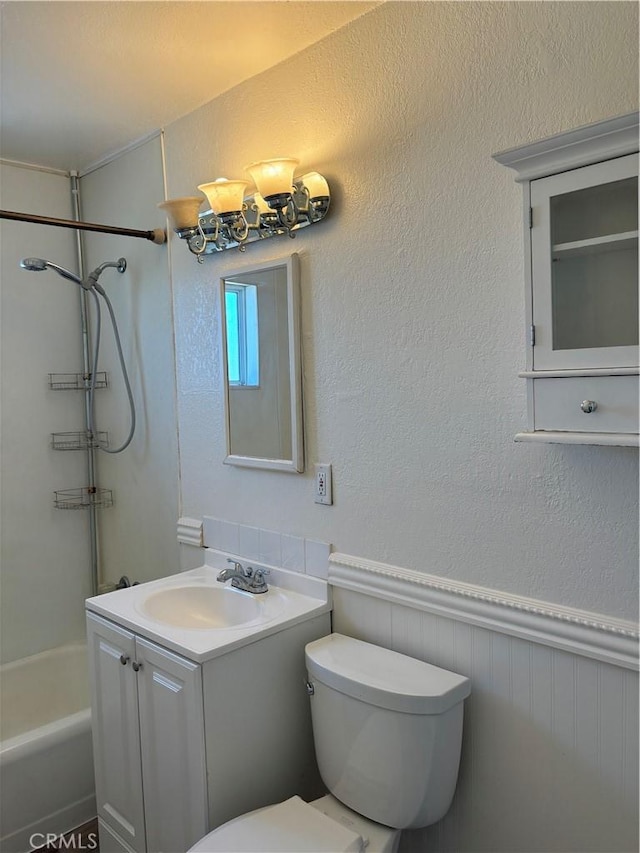6688 Yucca Ave Unit 29, Palms, CA 92277 - full bath with toilet, vanity,  shower combination, a textured wall, and a wainscoted wall
