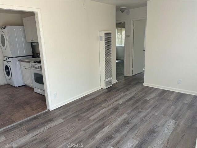 6688 Yucca Ave Unit 29, Palms, CA 92277 - unfurnished room featuring a heating unit, stacked washer / dryer, dark wood-style flooring, and baseboards