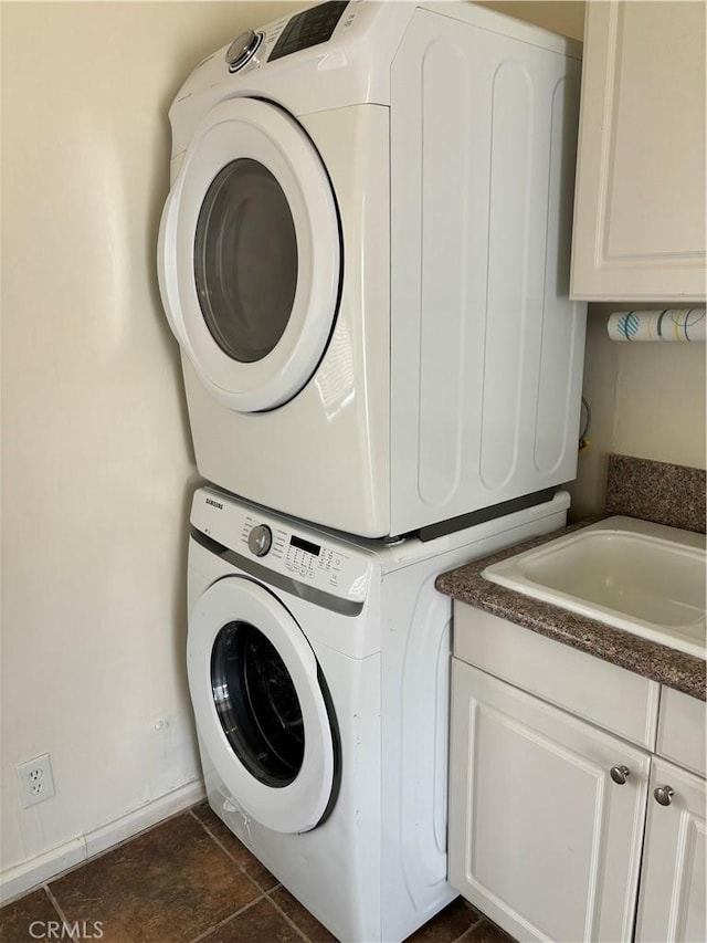 6688 Yucca Ave Unit 29, Palms, CA 92277 - clothes washing area featuring stacked washer / drying machine, cabinet space, and baseboards