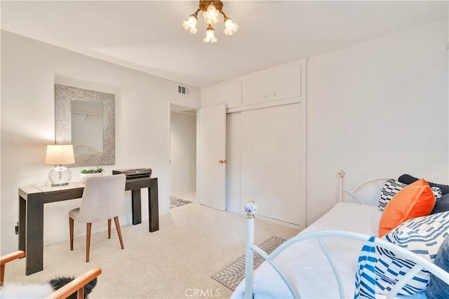 bedroom featuring light colored carpet, a chandelier, and a closet