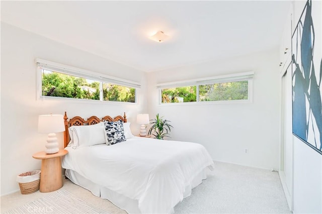 carpeted bedroom featuring multiple windows and baseboards