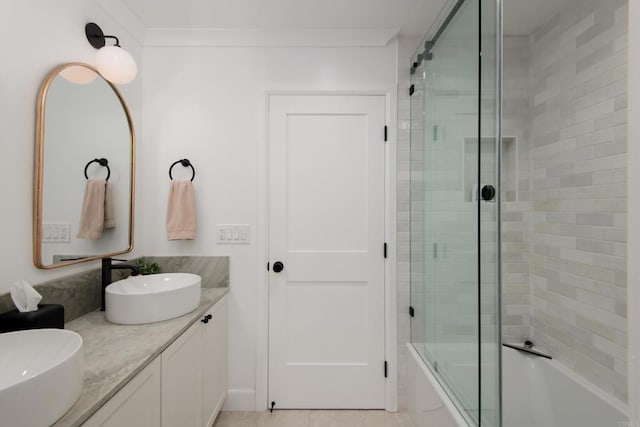 full bathroom with double vanity and shower / bath combination with glass door