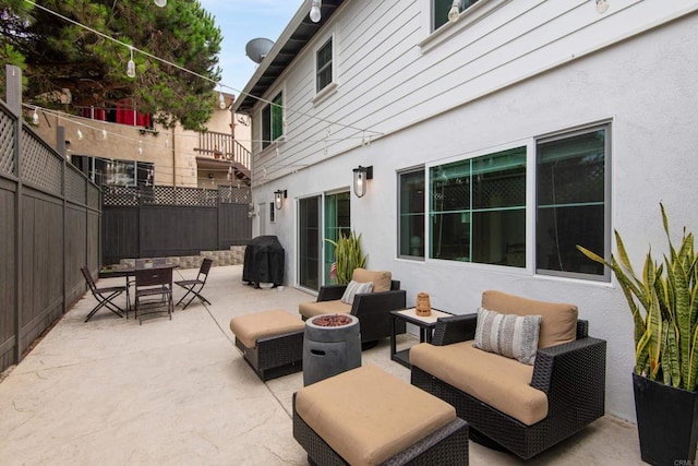 view of patio / terrace featuring an outdoor living space with a fire pit, a fenced backyard, outdoor dining space, and grilling area