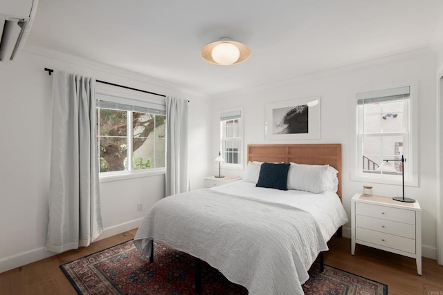 bedroom featuring wood finished floors, baseboards, and ornamental molding