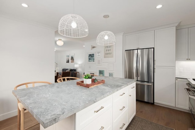kitchen with appliances with stainless steel finishes, dark wood finished floors, recessed lighting, white cabinets, and pendant lighting