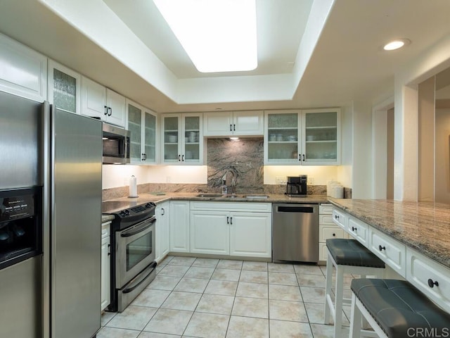 1099 1st St Unit 217, Coronado, CA 92118 - kitchen featuring appliances with stainless steel finishes, a sink, light stone countertops, light tile patterned floors, and tasteful backsplash