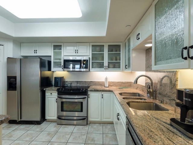 1099 1st St Unit 217, Coronado, CA 92118 - kitchen featuring appliances with stainless steel finishes, a sink, white cabinets, and light tile patterned flooring