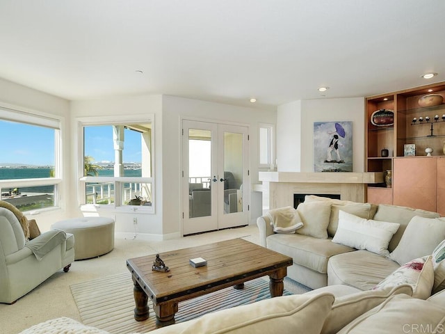 1099 1st St Unit 217, Coronado, CA 92118 - living area featuring a water view, light carpet, recessed lighting, french doors, and a fireplace